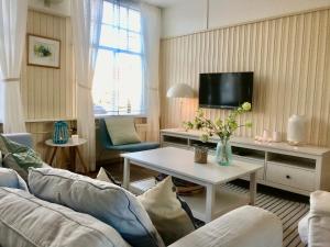 een woonkamer met een bank en een tafel bij Vakantiehuis Dorpsplein in Koudekerke