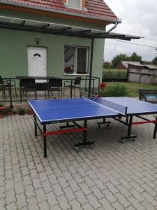 a ping pong table in front of a house at Attila Vendégház Tápiószentmárton in Tápiószentmárton