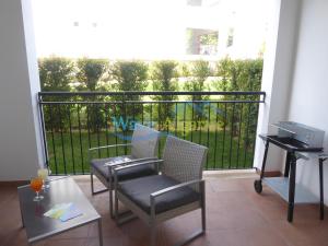 einen Balkon mit 2 Stühlen und einem Tisch mit Aussicht in der Unterkunft O Pomar in Cabanas by Wave Algarve in Cabanas de Tavira