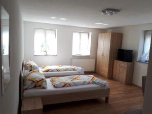 two beds in a room with two windows at Monteurhotel B27 in Rottweil