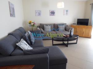 een woonkamer met een bank en een tafel bij O Pomar in Cabanas by Wave Algarve in Cabanas de Tavira