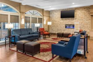 a living room with blue chairs and a tv at Comfort Inn MSP Airport - Mall of America in Bloomington