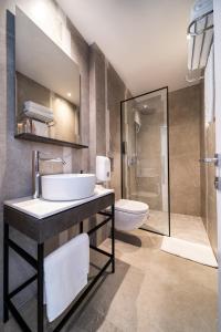 y baño con lavabo, aseo y ducha. en Alinea Suites Limassol Center, en Limassol