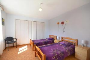 a bedroom with two beds and a chair at Villa charmante à Saint-Didier avec piscine privée in Saint-Didier +14 photos