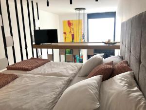 a room with three white beds and a table at Bjelasnica Tuzlaks Apartment -SAUNA-free parking in Bjelašnica