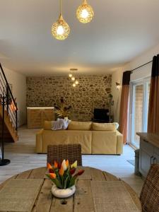 ein Wohnzimmer mit einem Sofa und einem Tisch in der Unterkunft La grange du bois in Fresnicourt-le-Dolmen