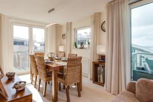 - une salle à manger avec une table, des chaises et des fenêtres dans l'établissement Sailaway, à Poole