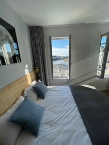 1 dormitorio con 1 cama grande y ventana en nuit sur le pont 4, en Landerneau