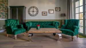 a living room with green chairs and a coffee table at The Starnbergsee Hideaway in Seeshaupt