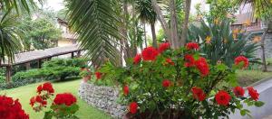 a garden with red flowers and a stone wall at Hotel Villa Adriana in Monterosso al Mare