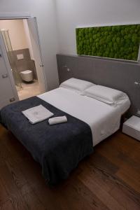een slaapkamer met een groot bed en 2 handdoeken bij La Corte sul Naviglio in Boffalora sopra Ticino