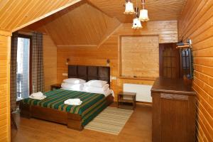 Un dormitorio con una cama en una habitación de madera. en Гук готельно-ресторанний комплекс, en Bukovel 28 fotos más