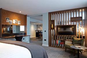 a hotel room with a bed and a flat screen tv at Telegraph Hotel - Coventry in Coventry