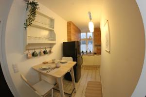 a small kitchen with a wooden table and a table and chairs at APARTAMENT CENTRUM OLSZTYNA in Olsztyn
