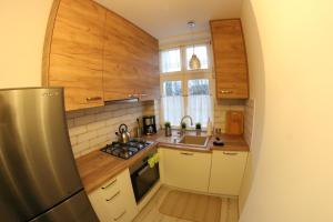 a small kitchen with a sink and a refrigerator at APARTAMENT CENTRUM OLSZTYNA in Olsztyn