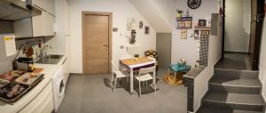 una pequeña cocina con una mesa, un lavabo y una escalera. en R&B La Pomposa dei Motori, en Módena