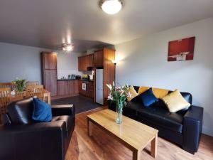 uma sala de estar com dois sofás pretos e uma mesa em Milligan Court Apartments em Sligo