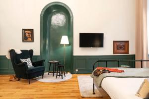 a bedroom with a bed and a chair and a tv at Les chambres chez Grand-mère à Chambéry in Chambéry