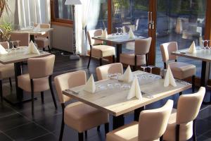 een restaurant met tafels en stoelen met servetten erop bij Hotel Bal in Tournehem