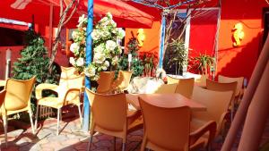 jadalnia ze stołami, krzesłami i kwiatami w obiekcie Max - Mamaia Nord w mieście Năvodari