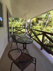 a table and a chair on a porch with a view at Magic Mountain Lodge in Las Lajas