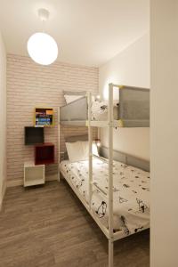 a bedroom with two bunk beds and a television at Séjour chaleureux en Baie de Somme in Saint-Valery-sur-Somme