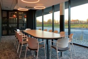 une salle de conférence avec une table et des chaises en bois dans l'établissement Hôtel Akena Troyes - La Chapelle St-Luc, à Troyes