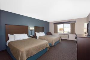 a hotel room with two beds and a television at AmericInn by Wyndham North Branch in North Branch