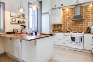 a kitchen with white cabinets and a wooden counter top at Kullagården in Vreta Kloster
