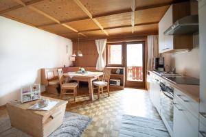 a kitchen and dining room with a table in a room at Schusterhof-Appartments in Dölsach