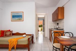 a room with a bed and a table and a kitchen at Bellos Hotel Apartments in Hersonissos