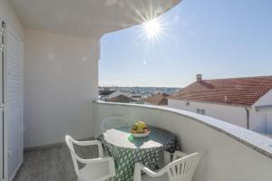 a small balcony with a table and chairs on it at Villa Anđelo in Trogir