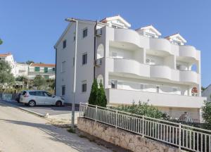 a white apartment building with a car parked in front at Villa Anđelo in Trogir