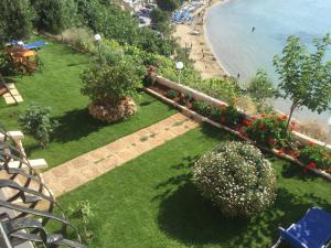 a view of a park with flowers and a beach at Villa Dina Apartments in Almyrida