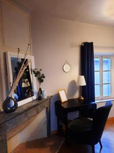 a living room with a desk and a fireplace at Les Suites de Sautet in Chambéry