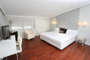 a bedroom with a white bed and white walls at Hotel Conde Rodrigo 2 in Ciudad-Rodrigo