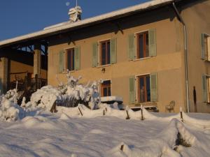 a house covered in snow in front of it at La Grange Du Haut in Saint-Antoine