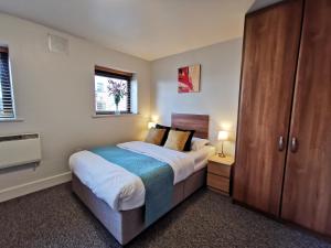 a bedroom with a bed and a wooden cabinet at Milligan Court Apartments in Sligo