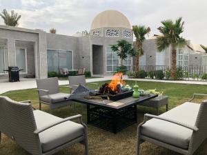 a patio with a table and chairs and a fire pit at Talah Resort in Riyadh
