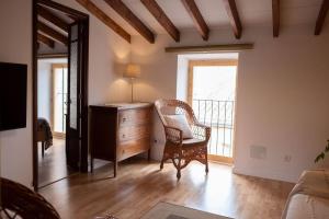 a living room with a chair and a dresser and a window at Sa Lluna in Santanyi