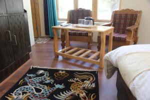 a room with a table and two chairs and a bed at New Moon Guest House in Leh
