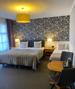 een hotelkamer met 2 bedden en een tafel en stoelen bij Hotel Hof van 's Gravenmoer in 's-Gravenmoer