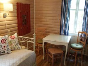 a bedroom with a bed and a table and chairs at Tammiston Cottages in Naantali
