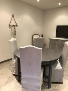 - une salle à manger avec une table, des chaises et une télévision dans l'établissement Oliviers, à Monteux