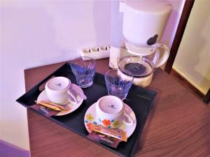 a table with a coffee maker and cups on it at Diporto in Chania