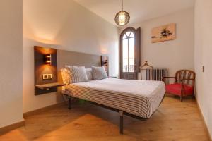 1 dormitorio con 1 cama con ventana y silla en MoneoHeritage, en Salamanca