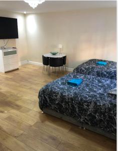 - une chambre avec un lit et une table avec des chaises dans l'établissement BIG ROOM rusholme WITH TV AND PRIVATE BATHROOM-parking&wifi, à Manchester
