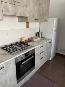 a kitchen with a stove and a refrigerator at RESIDENZA VILLA LEONIDA in SantʼAmbrogio di Valpolicella