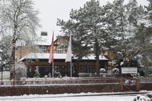 a building with two flags in the snow at Hotel Seeschlösschen in Groß Köris