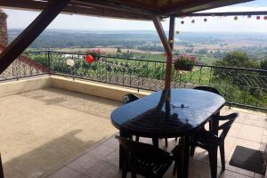 uma mesa e cadeiras em uma varanda com vista em Vue panoramique sur le vignoble em Sancerre mais 5 fotografias